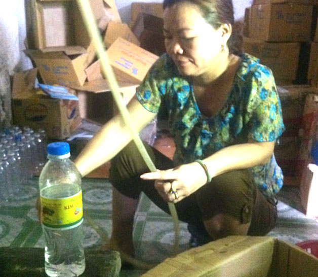  pha chế nửa l&iacute;t axit với 50 l&iacute;t nước lạnh v&agrave;o th&ugrave;ng phuy rồi đổ thủ c&ocirc;ng v&agrave;o c&aacute;c chai nhựa c&oacute; dung t&iacute;ch 550ml
