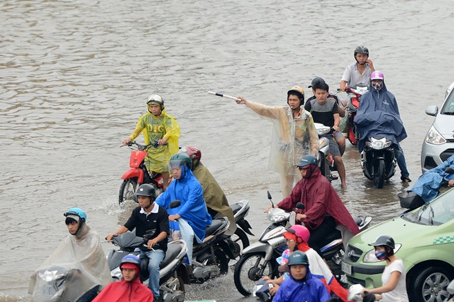 Cảnh sát giao thông tại những điểm ngập vất vả điều tiết các phương tiện tránh ùn tắc.