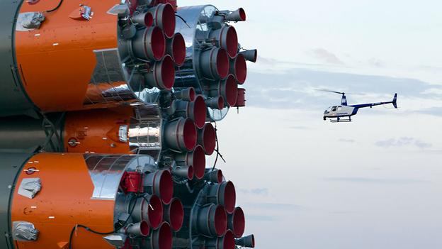      Một máy bay trực thăng của cảnh sát bay qua tàu vũ trụ Soyuz TMA-14M. Đây là chiến tàu được vận chuyển đến bệ phóng tại Baikonur Cosmodrome. (Shamil Zhumatov / Reuters)