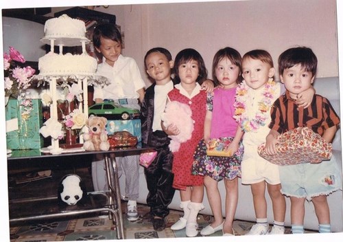 La Quốc Hùng (đeo vòng hoa) nổi bật so với các bạn đồng trang lứa nhờ khuôn mặt lai Tây, làn da trắng và mái tóc nâu hạt dẻ.