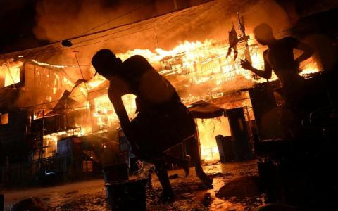 Người d&acirc;n Philippines nỗ lực dập tắt đ&aacute;m ch&aacute;y ở một khu ổ chuột tại thủ đ&ocirc; Manila do đốt ph&aacute;o dịp Năm mới