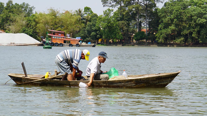 Nh&agrave; nghi&ecirc;n cứu Phạm Văn Mi&ecirc;n lấy mẫu nước tr&ecirc;n s&ocirc;ng Đồng Nai để xem x&eacute;t chất lượng sau khi c&oacute; dự &aacute;n lấn s&ocirc;ng