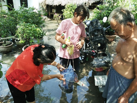  Người d&acirc;n đổ x&ocirc; đi bắt c&aacute; sau khi vỡ bờ bao. Ảnh: Lao Động