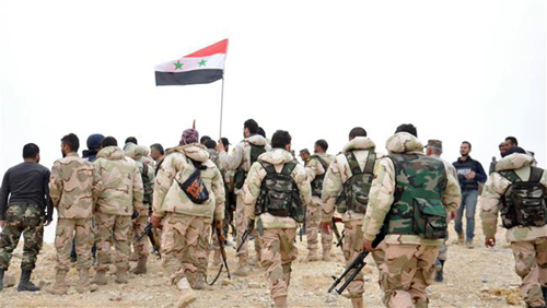 Chiến sự Syria: Binh sĩ Syria tập trung quanh l&aacute; quốc kỳ. Ảnh: SANA/AP