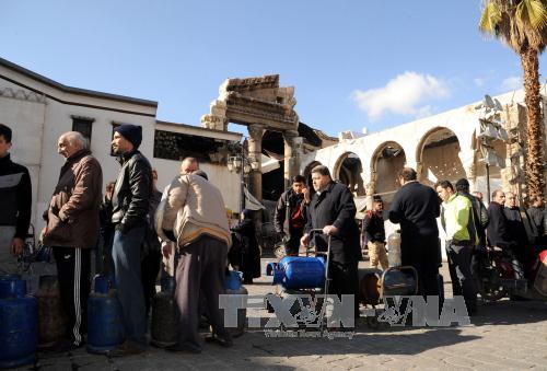  Chiến sự Syria: Người d&acirc;n Syria xếp h&agrave;ng chờ mua gas trong kh&ocirc;ng kh&iacute; y&ecirc;n b&igrave;nh ở Damascus ng&agrave;y 30/12. Ảnh: EPA/TTXVN