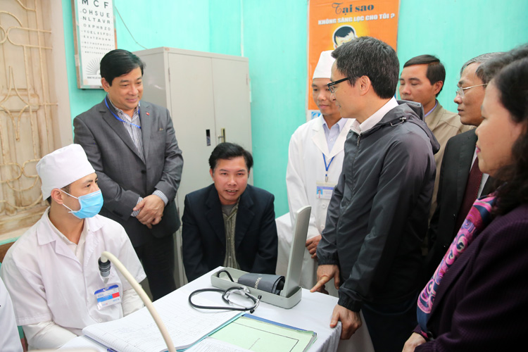 Ph&oacute; Thủ tướng Vũ Đức Đam tr&ograve; chuyện với một người d&acirc;n kh&aacute;m bệnh tại trạm y tế x&atilde; Minh Đức, huyện Việt Y&ecirc;n, tỉnh Bắc Giang. Ảnh: VGP