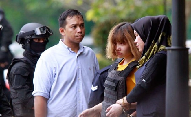  Đo&agrave;n Thị Hương (&aacute;o v&agrave;ng) được cảnh s&aacute;t &aacute;p giải ra khỏi t&ograve;a &aacute;n tại Malaysia h&ocirc;m 1/3. Ảnh: AP