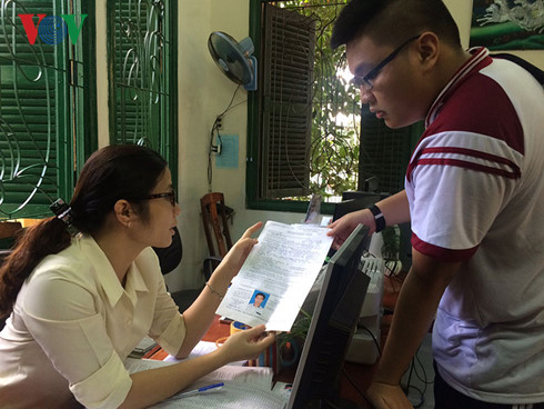  C&aacute;n bộ nh&agrave; trường hướng dẫn c&aacute;c th&iacute; sinh điền hồ sơ thi THPT Quốc gia. Ảnh: VOV