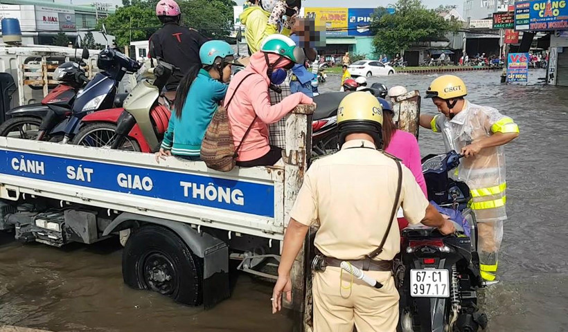 CSGT phải d&ugrave;ng xe chuy&ecirc;n dụng để chở người v&agrave; phụ nữ qua điểm ngập. Ảnh: Thanh ni&ecirc;n 
