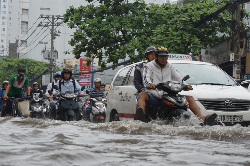 Đường Nguyễn X&iacute; (Q.B&igrave;nh Thạnh) tại khu vực từ giao lộ với đường Đinh Bộ Lĩnh tới gần cầu Đỏ, nước ngập hơn nửa b&aacute;nh xe khiến h&agrave;ng loạt phương tiện chết m&aacute;y phải dắt bộ. Ảnh: Lao Động 