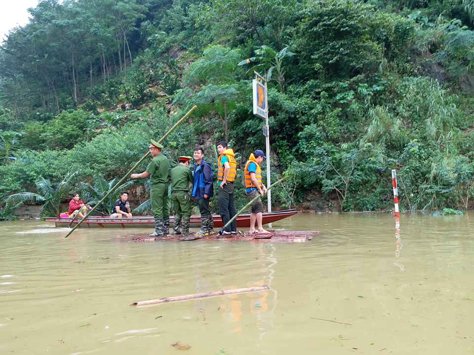  C&aacute;c chiến sĩ c&ocirc;ng an ch&egrave;o b&egrave; đưa người d&acirc;n qua đường ngập lụt ở ng&atilde; ba Thung Khe đi Sơn La. Ảnh: Th&igrave;n L&agrave; T&ocirc;i