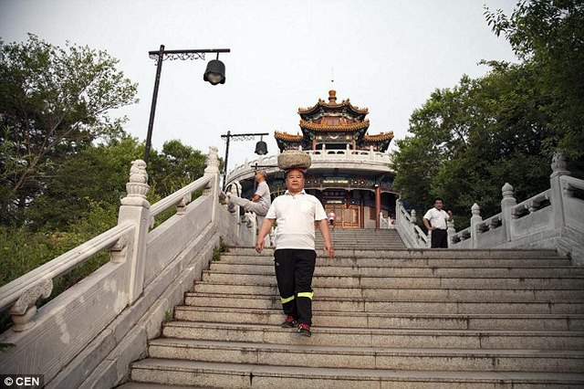 L&ecirc;n xuống bậc thang cũng l&agrave; một b&agrave;i tập của &ocirc;ng với tảng đ&aacute; tr&ecirc;n đầu. Ảnh: Daily Mail