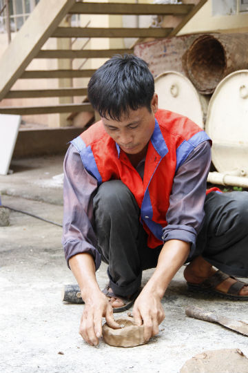 Các nghệ nhân hướng dẫn các cháu chơi pháo đất.