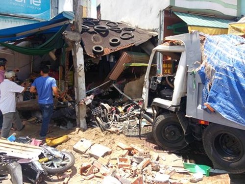 Chiếc xe tải đã được kéo ra ngoài, lộ hiện trường bên trong là cảnh đổ nát, nhiều xe máy bẹp dúm. Trong khi đó, xăng dầu từ chiếc xe đang rò rỉ ra ngoài.