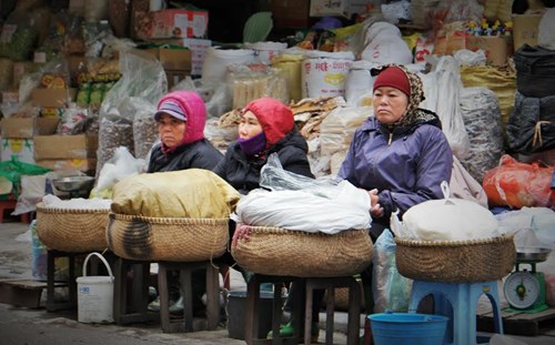 Những người phụ nữ “co ro” trong chiếc áo ấm chờ khách mua hàng. Ảnh: Tiền Phong
