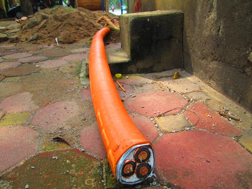 Đường d&acirc;y m&agrave;u cam ch&ocirc;n dưới ch&acirc;n HV Ch&iacute;nh trị Quốc gia Hồ Ch&iacute; Minh l&agrave; đường d&acirc;y điện trung thế