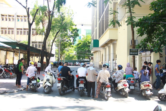Phụ huynh chờ con trong nắng n&oacute;ng