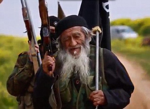 H&igrave;nh ảnh Muhammed Amin v&aacute;c s&uacute;ng aka v&agrave; cầm l&aacute; cờ IS