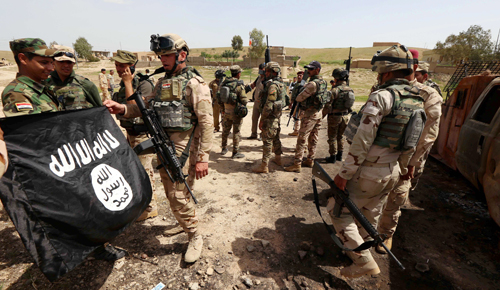 Binh sĩ Iraq cầm một l&aacute; cờ tịch thu từ phiến qu&acirc;n khủng b&ocirc;́ IS ở chiến trường thị trấn Kharbardan, tỉnh Nineveh 