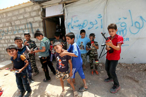 Trẻ em Iraq chơi c&ugrave;ng những khẩu s&uacute;ng đồ chơi ph&iacute;a ngo&agrave;i một trại tị nạn ở ngoại &ocirc; th&agrave;nh phố Arbil h&ocirc;m 17/7
