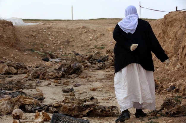 Một người d&acirc;n Yazidi đang t&igrave;m kiếm thi thể người nh&agrave; trong số những nạn nh&acirc;n bị IS giết hại 