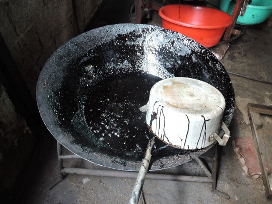 Chảo d&ugrave;ng để nấu caramen đen đặc, ch&aacute;y kh&eacute;t tại cơ sở rang c&agrave; ph&ecirc; bẩn