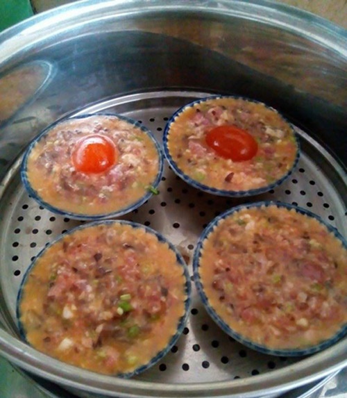 Cho hỗn hợp thịt v&agrave;o ch&eacute;n nhỏ rồi đặt l&ograve;ng đỏ trứng muối l&ecirc;n tr&ecirc;n