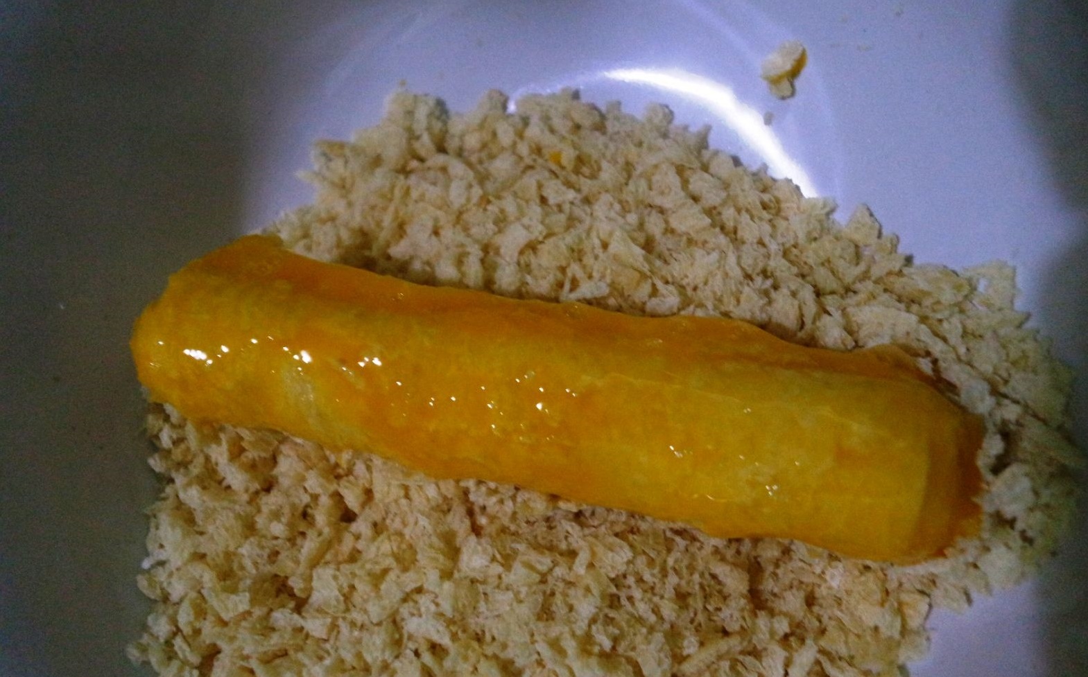 &Aacute;o một lớp l&ograve;ng đỏ trứng rồi lăn cuộn b&aacute;nh m&igrave; x&uacute;c x&iacute;ch v&agrave;o lớp bột chi&ecirc;n x&ugrave;