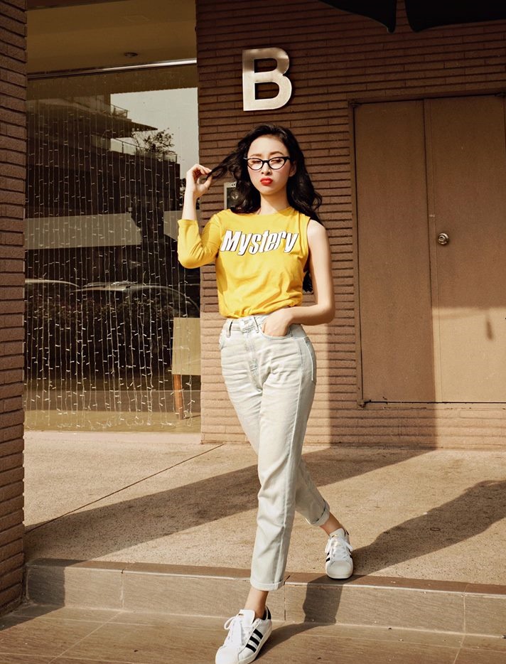 Tr&aacute;i ngược với Yến Trang, Angela Phương Trinh phối quần trắng x&aacute;m c&ugrave;ng &aacute;o ph&ocirc;ng v&agrave;ng để tạo cảm gi&aacute;c trẻ trung, tinh nghịch
