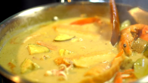 Bước 3: Cho tiếp khoai t&acirc;y, c&agrave; t&iacute;m, c&agrave; chua, t&ocirc;m, mực, chả c&aacute; v&agrave;o v&agrave; đun s&ocirc;i trong khoảng 10 &ndash; 15 ph&uacute;t, để lửa vừa. Cuối c&ugrave;ng cho rau h&uacute;ng quế v&agrave;o đảo đều rồi tắt bếp.
