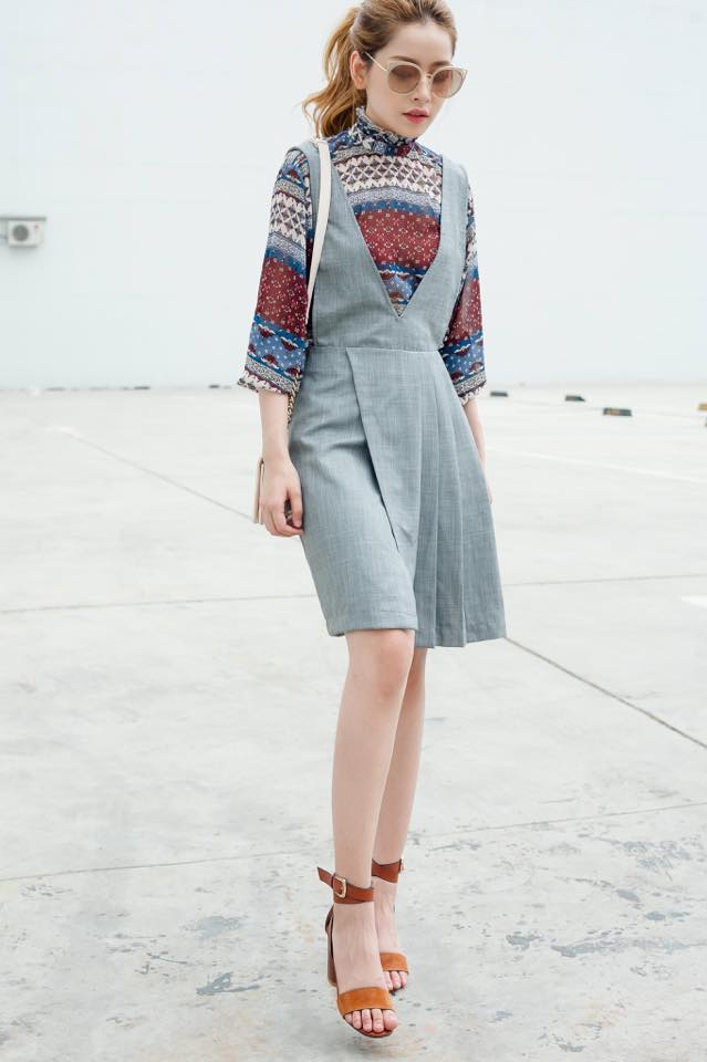 Chi Pu gợi &yacute; c&aacute;ch mix đồ thanh lịch cho qu&yacute; c&ocirc; c&ocirc;ng sở với v&aacute;y yếm từ chất liệu kaki kết hợp với sơ mi hoạ tiết nổi bật.