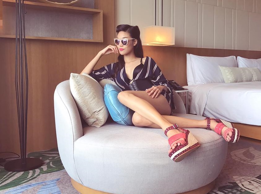 Đ&ocirc;i sandals đế xuồng đỏ hồng với phần đinh t&aacute;n nổi bật, t&ocirc;n l&ecirc;n bộ trang phục tối m&agrave;u.