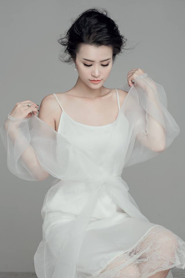 Ca sĩ Đ&ocirc;ng Nhi với đầm trắng dịu d&agrave;ng, thể hiện được vẻ đẹp tinh kh&ocirc;i, trong s&aacute;ng