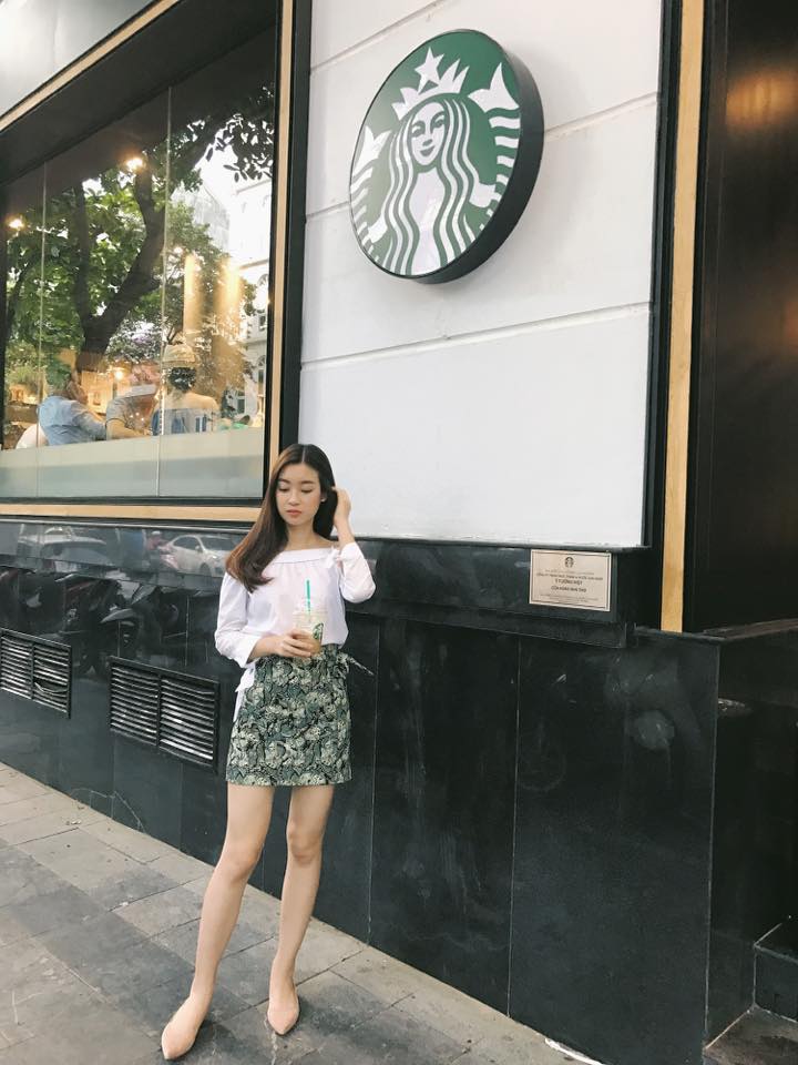 Ch&acirc;n v&aacute;y in hoa mix c&ugrave;ng &aacute;o trễ vai m&agrave;u trắng khiến Đỗ Mỹ Linh năng động, tự tin khi dạo phố