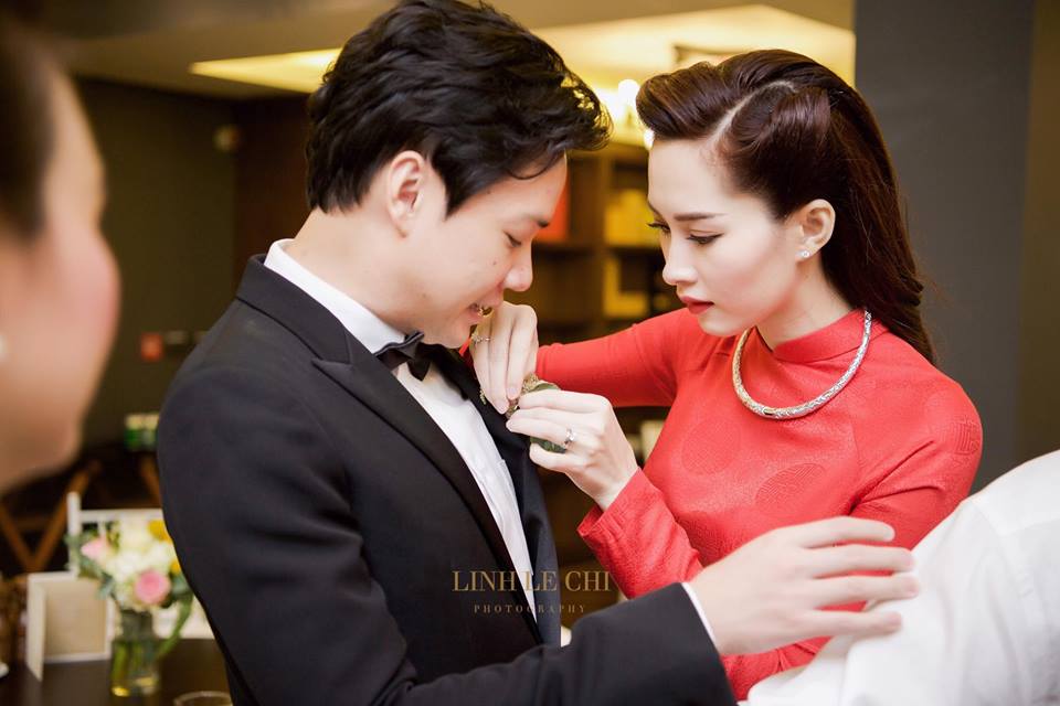 Đặng Thu Thảo kh&eacute;o l&eacute;o chỉnh hoa c&agrave;i &aacute;o cho chồng. Ảnh: L&ecirc; Ch&iacute; Linh