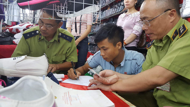 Lực lượng chức năng tiến h&agrave;nh xử l&yacute; gian h&agrave;ng vi phạm.