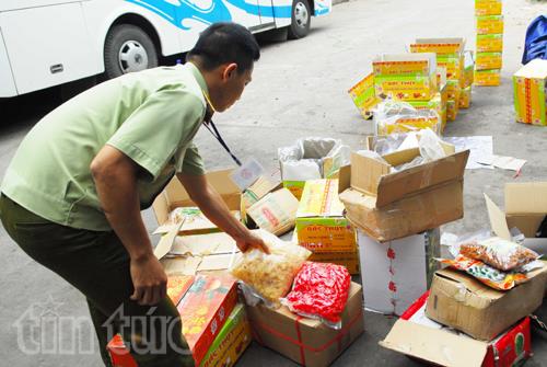 Lực lượng chức năng tiến h&agrave;nh kiểm tra số mứt Tết vừa ph&aacute;t hiện. Ảnh: TTXVN