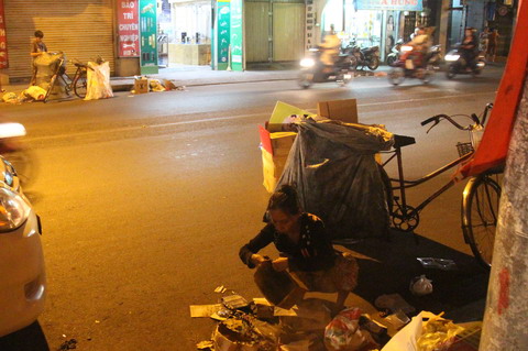 Mẹ bên này con bên kia, hai mẹ con cùng nhặt phế liệu. Ảnh: Vietnamnet