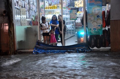 Một số nhà trọ công nhân thuê ở, do nước ngập nên đành phải khóa cửa tới nhà bạn ở tạm. Công việc buôn bán của những hộ dân ở khu vực đường Ấp Chiến Lược cũng bị ế ẩm do bị nước bao vây. Ảnh Vietnamnet