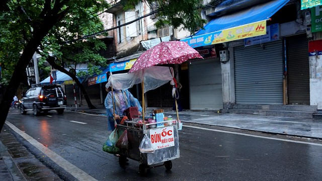 Người phụ nữ vẫn mưu sinh trong mưa lạnh giữa Thủ đô. Ảnh Sưu tầm