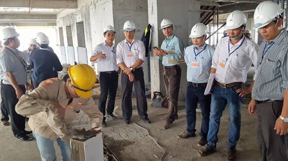 C&aacute;c học vi&ecirc;n đang tham quan t&igrave;m hiểu quy tr&igrave;nh thi c&ocirc;ng gạch x&acirc;y kh&ocirc;ng nung một c&ocirc;ng tr&igrave;nh ở B&igrave;nh Dương