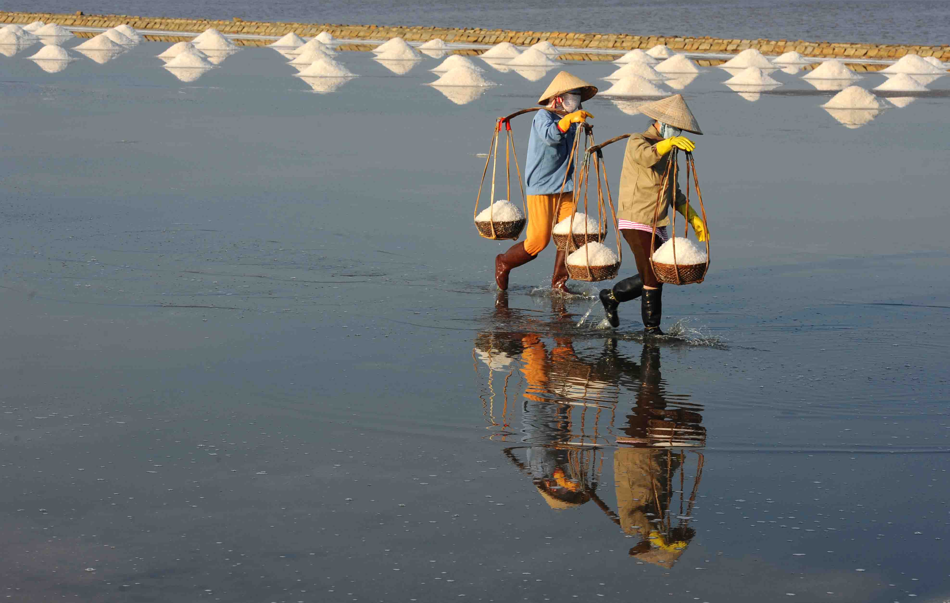 Lao động trên những cánh đồng muối tất bật lúc trời chiều Lao động trên những cánh đồng muối tất bật lúc trời chiều
