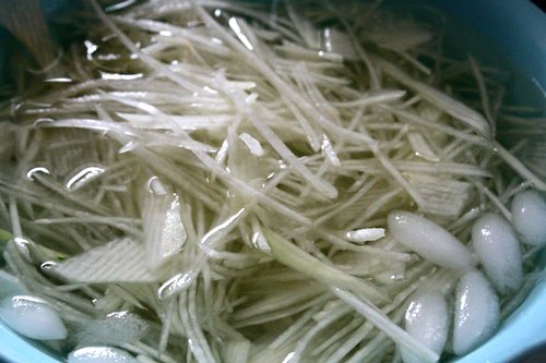 B&agrave;o đu đủ th&agrave;nh từng sợi mỏng rồi ng&acirc;m v&agrave;o nước đ&aacute;