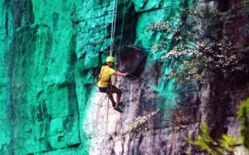 Người đ&agrave;n &ocirc;ng Trung Quốc thu&ecirc; c&ocirc;ng nh&acirc;n phun sơn xanh l&aacute; c&acirc;y l&ecirc;n mặt v&aacute;ch n&uacute;i để 'hợp phong thủy'
