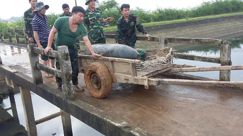 Quả bom được lực lượng c&ocirc;ng binh đưa l&ecirc;n khỏi mặt đất 