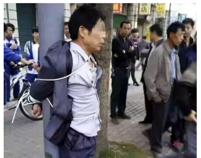 Kẻ chuy&ecirc;n quấy rối nữ sinh đ&atilde; bị cha mẹ nạn nh&acirc;n r&igrave;nh bắt v&agrave; tr&oacute;i v&agrave;o cột đ&egrave;n giao th&ocirc;ng