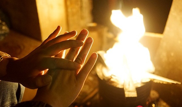 Nhiều người đi đường đã phải dừng lại, đến gần những bếp lửa để sưởi ấm cho bớt lạnh rồi mới lên đường đi tiếp. Ảnh: Infonet
