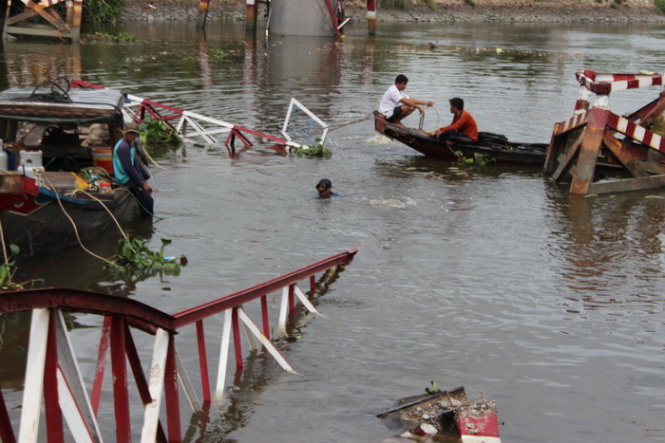 C&aacute;c c&ocirc;ng nh&acirc;n đang lặn để k&eacute;o c&acirc;y cầu bị sập l&ecirc;n l&agrave;m cầu mới