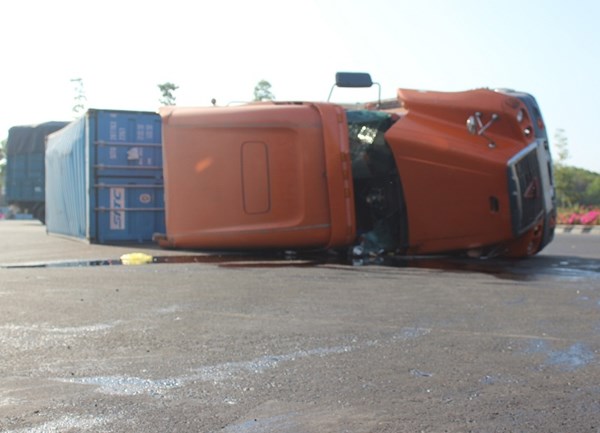 Sau tai nạn lật xe container, dầu nhớt l&ecirc;nh l&aacute;ng khắp đường