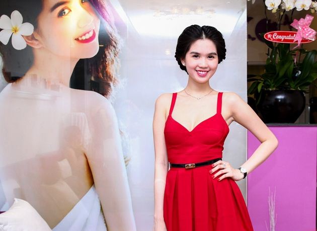 Ngọc Trinh làm dáng trong ngày khai trương (trái) trong phòng khách của spa với sàn gỗ bóng láng và bộ salon + trần nhà màu tím trẻ trung
